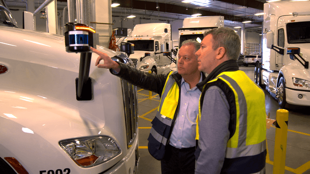 Chuck Price points out a sensor on the front of a freight truck to CBS reporter Jon Wertheim.