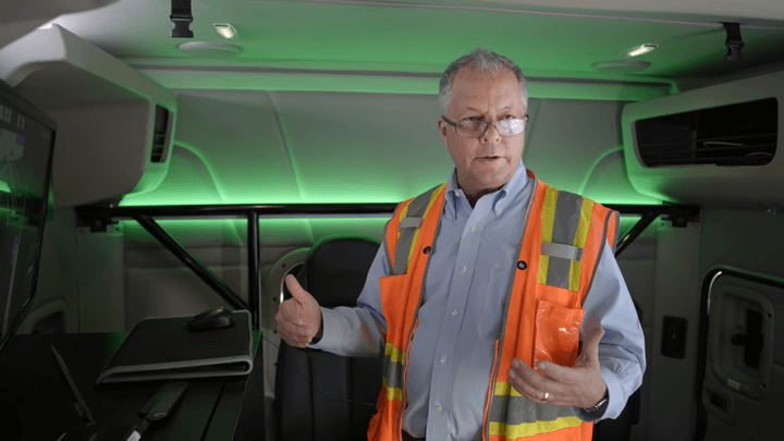 Chuck Price with technical equipment in the cabin of an autonomous freight truck.